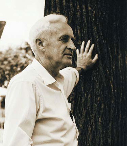 Historical photo of Dan West leaning on a tree.