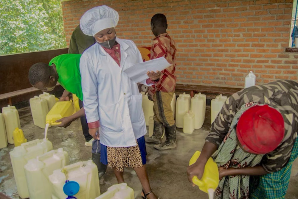 Rwandan dairy farmers deliver fresh milk to a local milk collection point.
