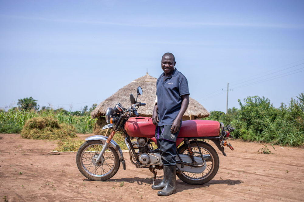 Ambrose Omongi proudly displays his motorcycle.