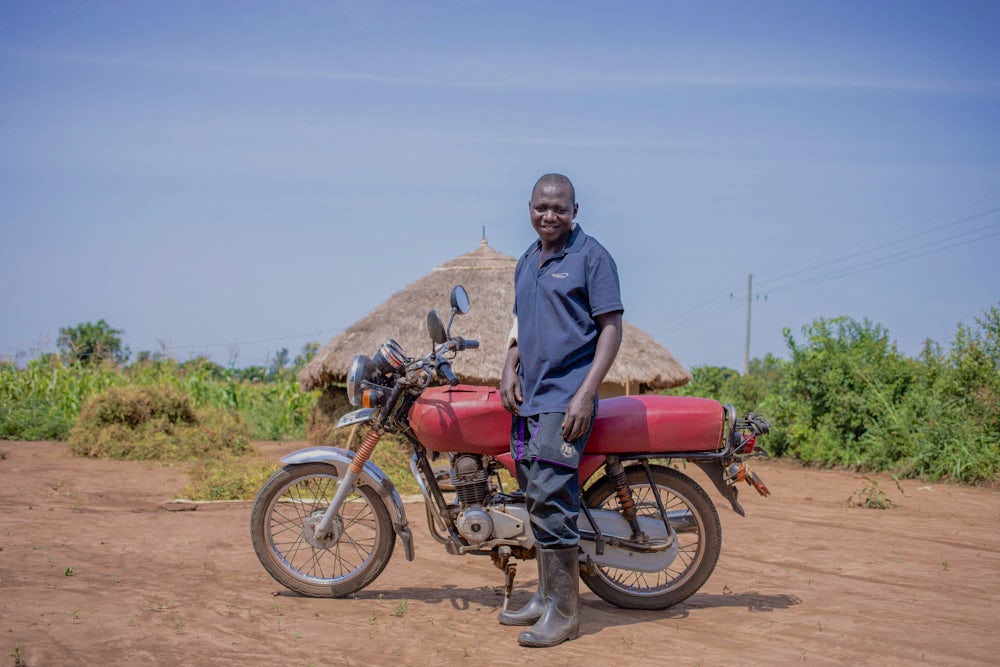 Ambrose Omongi proudly displays his motorcycle.