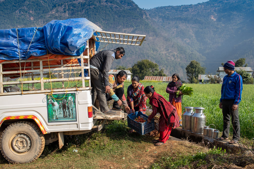 Local farmers in Cherlung village, Palpa, Nepal, load their products onto an agri-transport vehicle for market delivery.