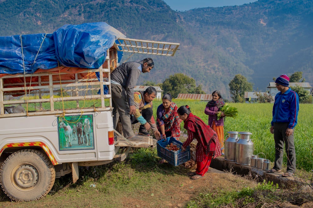 Local farmers in Cherlung village, Palpa, Nepal, load their products onto an agri-transport vehicle for market delivery.