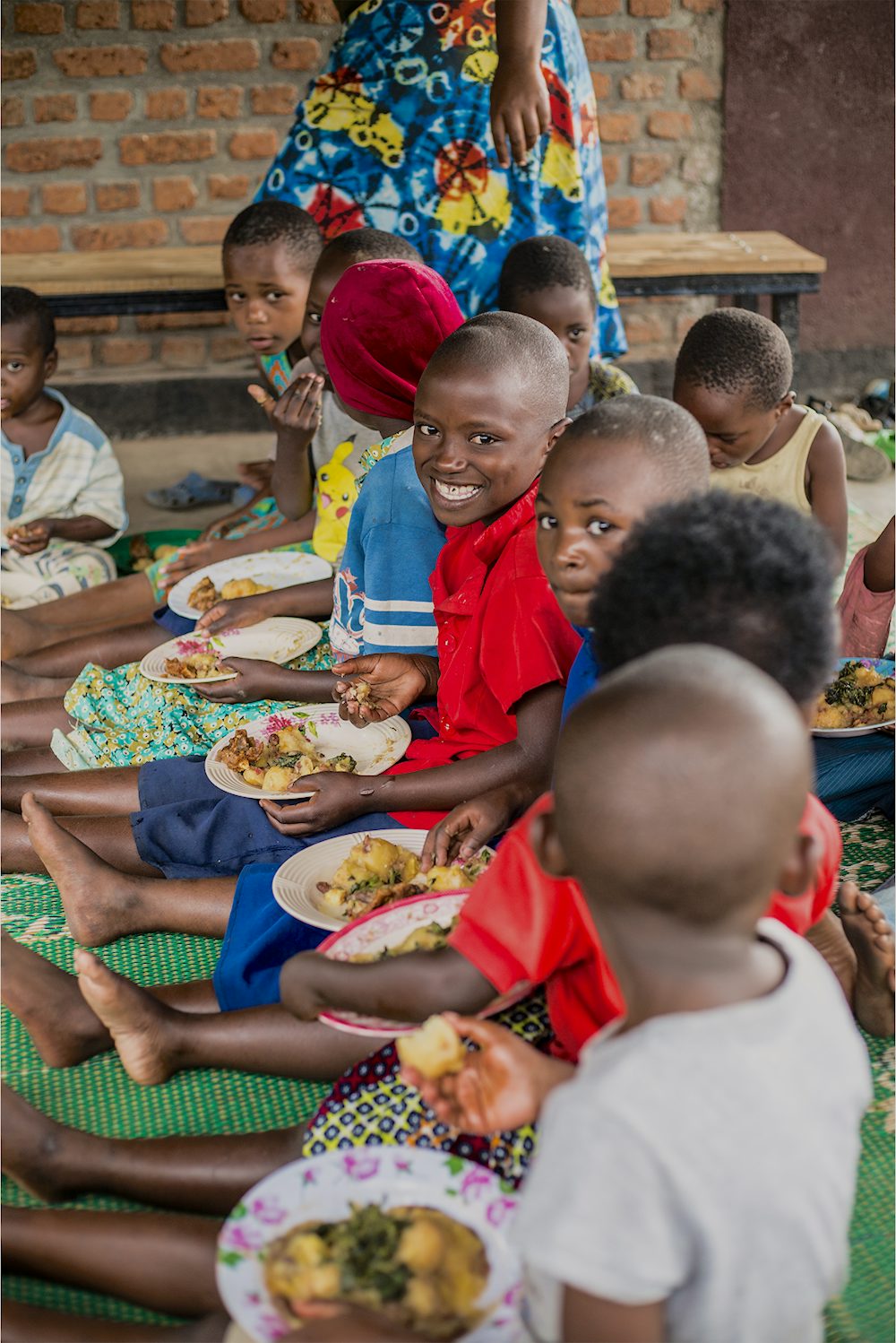 A group of children sit together and enjoy a meal.