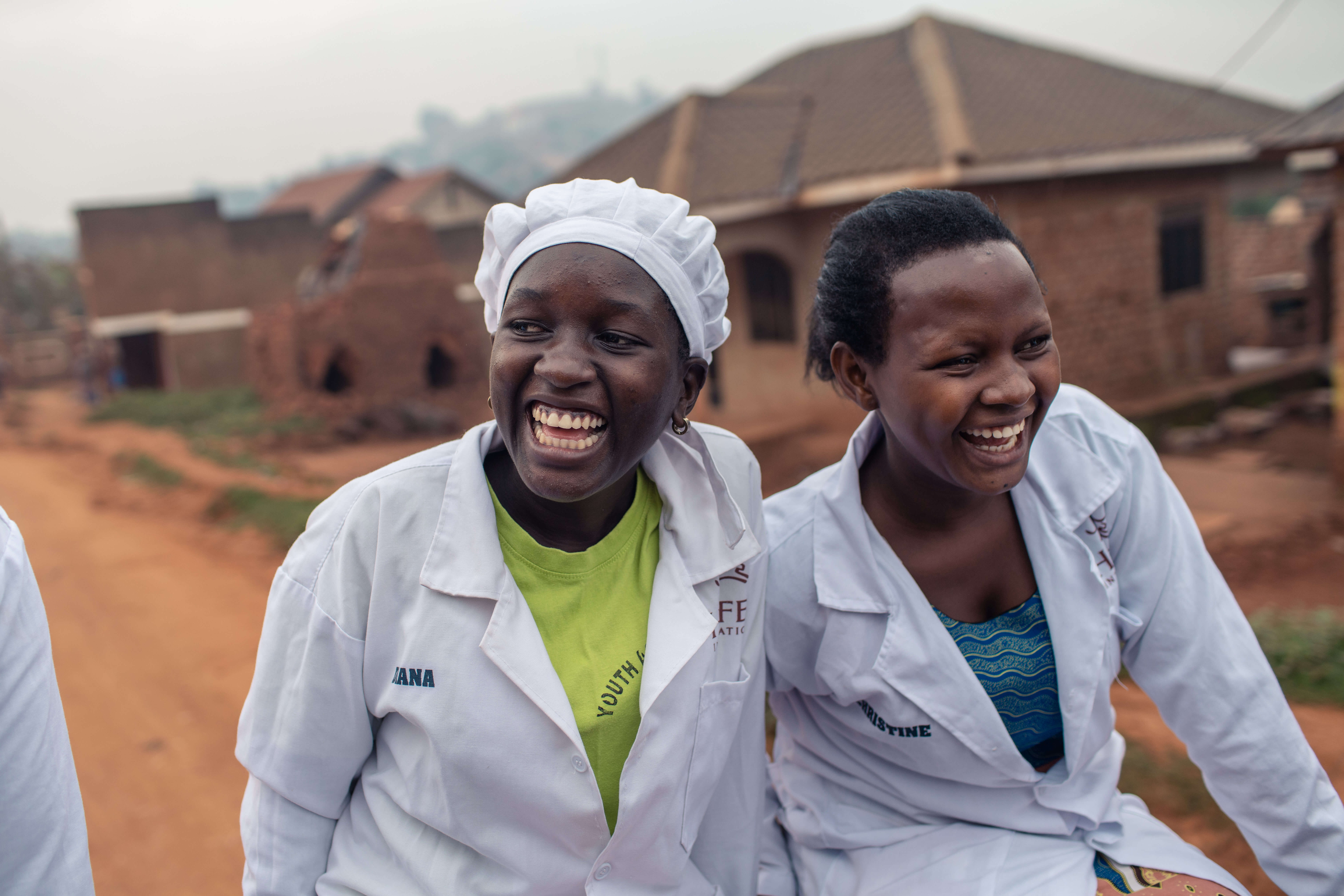 Two women laugh as they travel down a rural road.