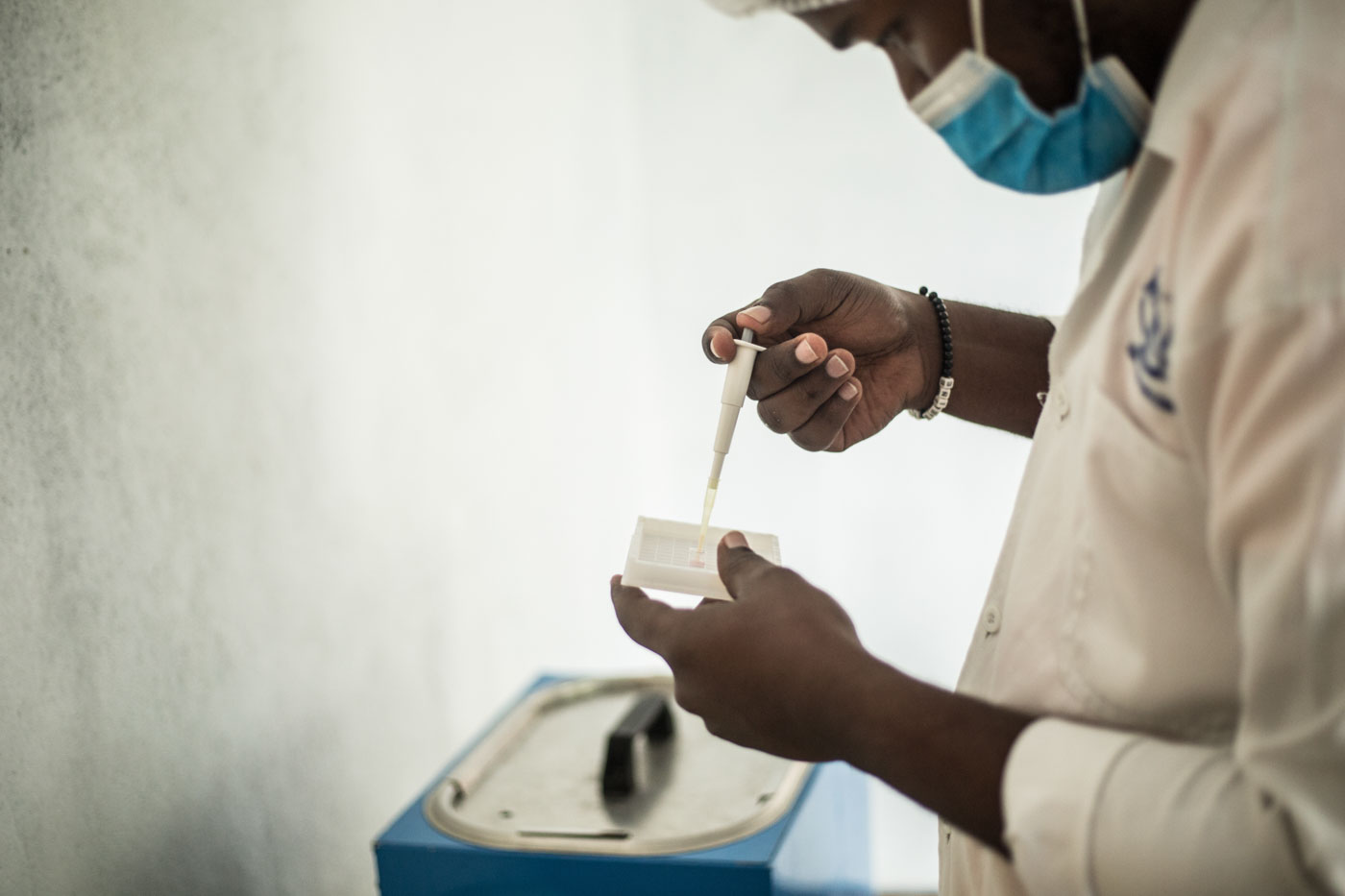 A worker uses a syringe to test milk quality.