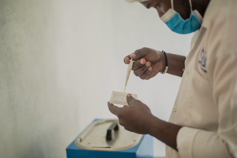 A worker uses a syringe to test milk quality.