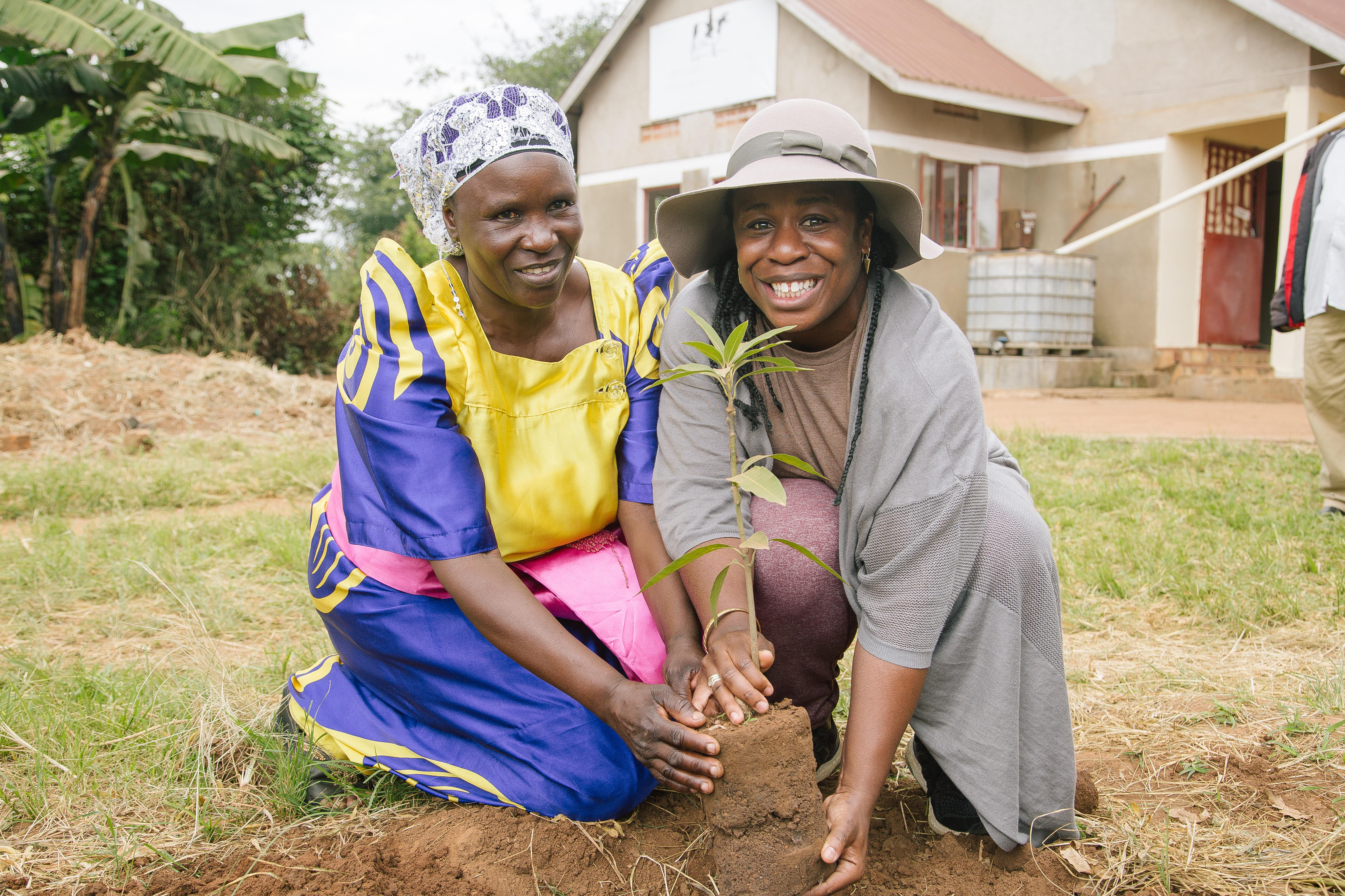 Aduba helps plant a mango tree.