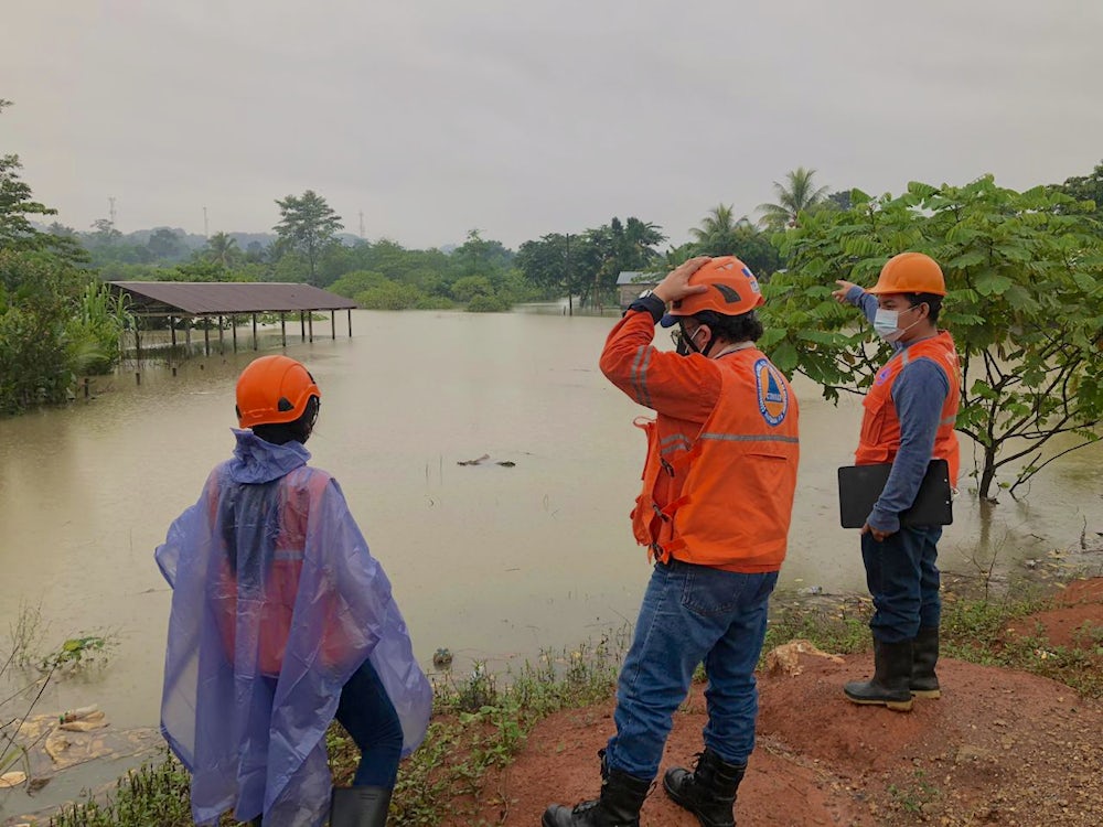 Emergency workers survey flooding in Chisec, Guatemala. 